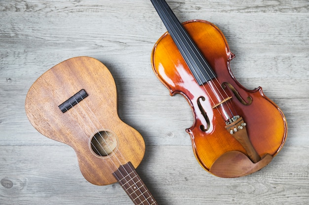 木製の背景に古典的なギターとバイオリンのオーバーヘッドビュー