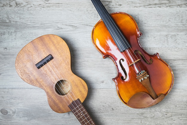 Overhead view of classical guitar and violin on wooden backdrop