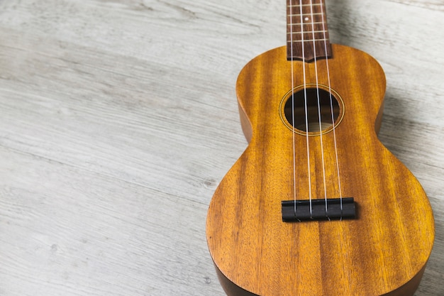 Overhead view of classical wooden guitar string on wooden plank backdrop