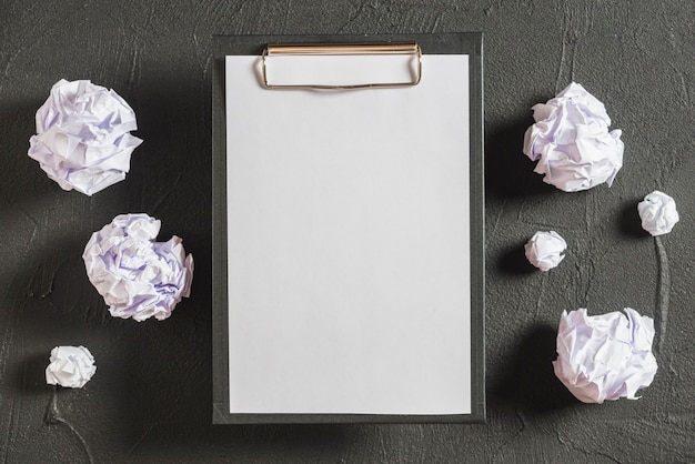 Overhead view of clipboard and crumpled papers