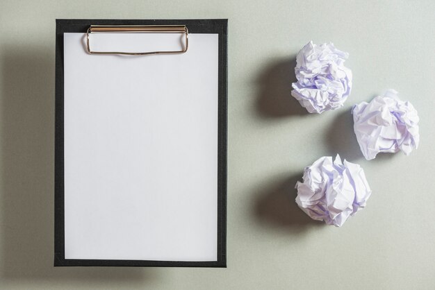 Overhead view of clipboard and crumpled papers