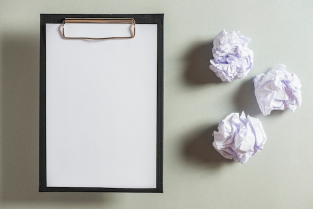 Overhead view of clipboard and crumpled papers