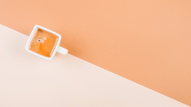 An overhead view of coffee cup on dual background