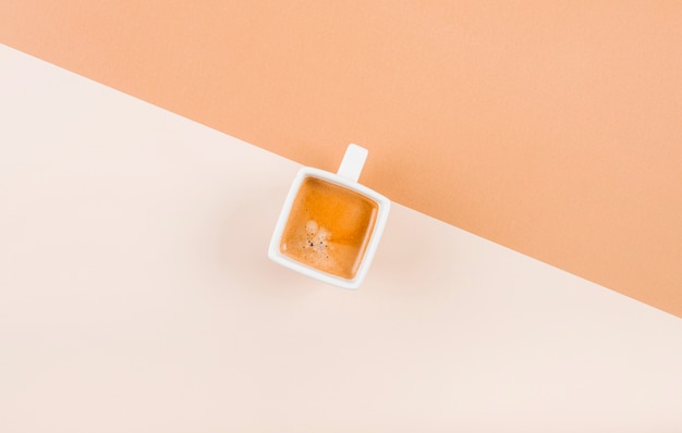 An overhead view of coffee cup on dual background