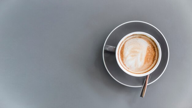 Overhead view of coffee latte on grey background