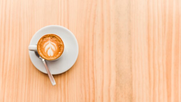 Overhead view of coffee latte on wooden background