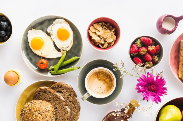 Overhead view of coffee with healthy snack on white background