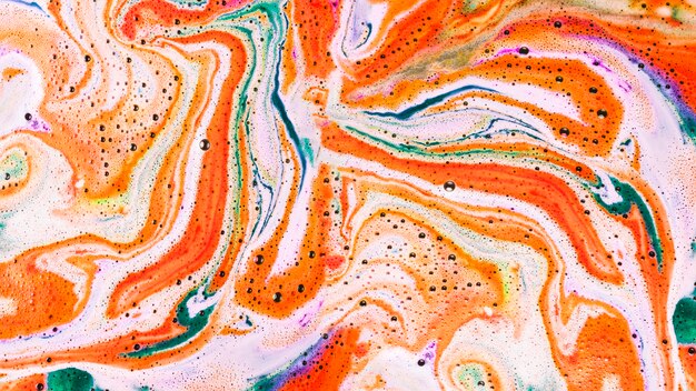 An overhead view of color bath bomb foam in water
