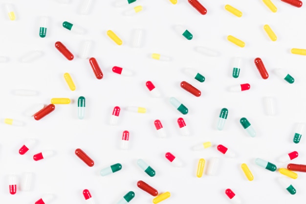 Free photo overhead view of colorful capsules on white background