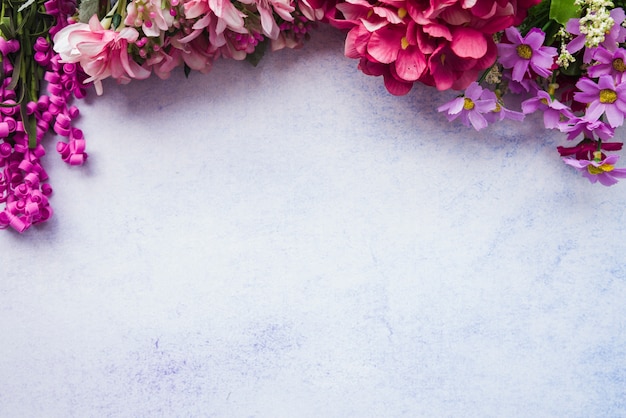 An overhead view of colorful flowers on white textured background