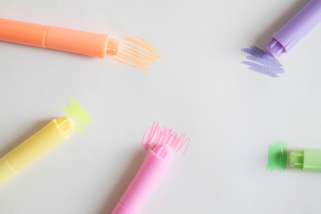 Overhead view of colorful markers on grey background