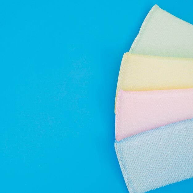 An overhead view of colorful sponge on blue background