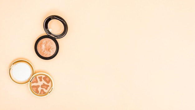 An overhead view of compact face powder on colored background