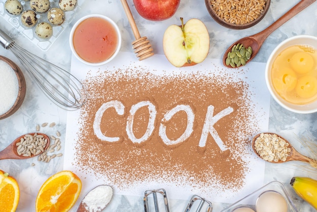 Overhead view of cook writing with coffee oats flour fresh fruits eggs on ice background