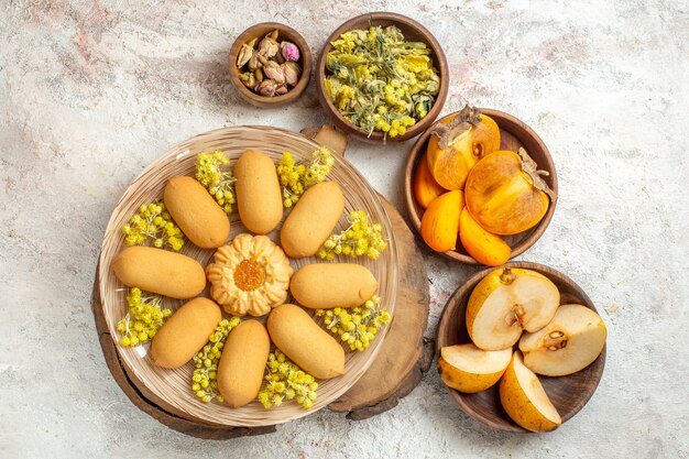 Overhead View Of Cookies And Bowls Of Dry Lavender And Yellow Flowers And Pear And Palm