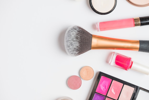 Overhead view of cosmetic products on white backdrop