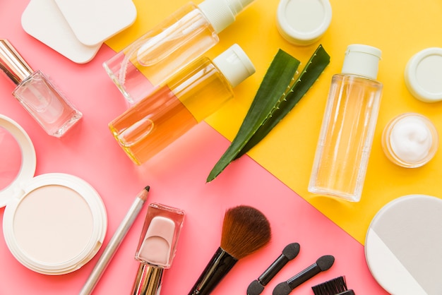 An overhead view of cosmetics makeup and natural organic products on dual backdrop