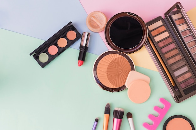 An overhead view of cosmetics products on colored background