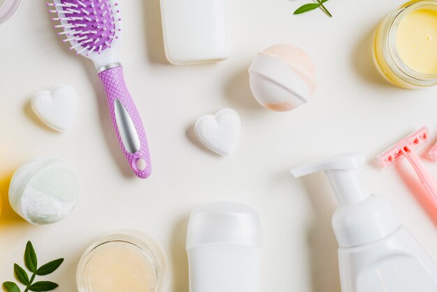 An overhead view of cosmetics products with hairbrush and razor