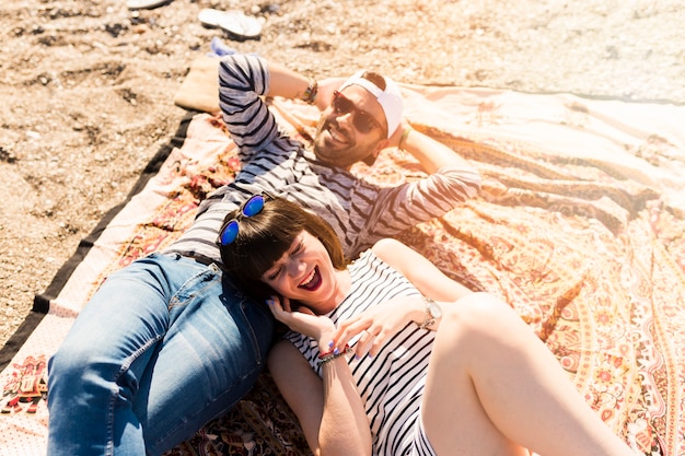 Overhead view of couple lying on blanket at beach