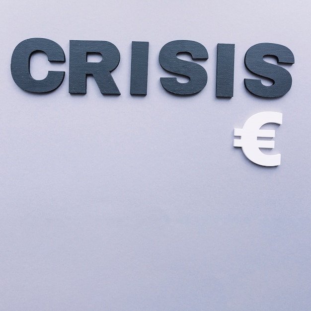 Overhead view of crisis word with euro sign on grey background