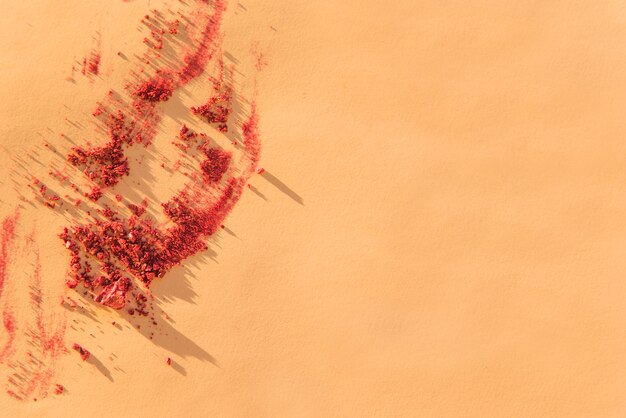 An overhead view of crushed cosmetic face powder on colored backdrop