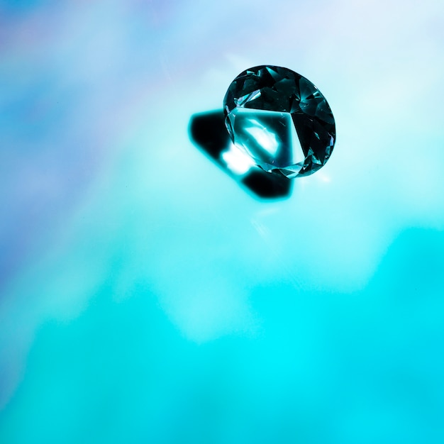 Free photo an overhead view of crystal diamond on blue background