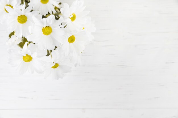 An overhead view of daisy bouquet over the wooden backdrop