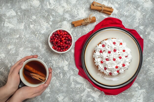 Overhead view of delicious creamy cake decorated with fruits on a red towel