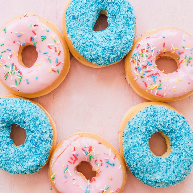 Free photo overhead view of delicious donuts on pink backdrop