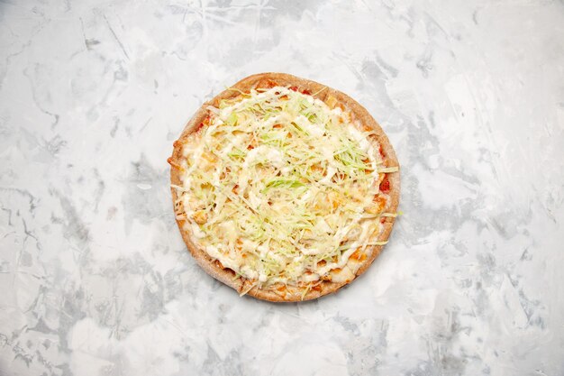 Overhead view of delicious homemade vegan pizza on stained white surface with free space