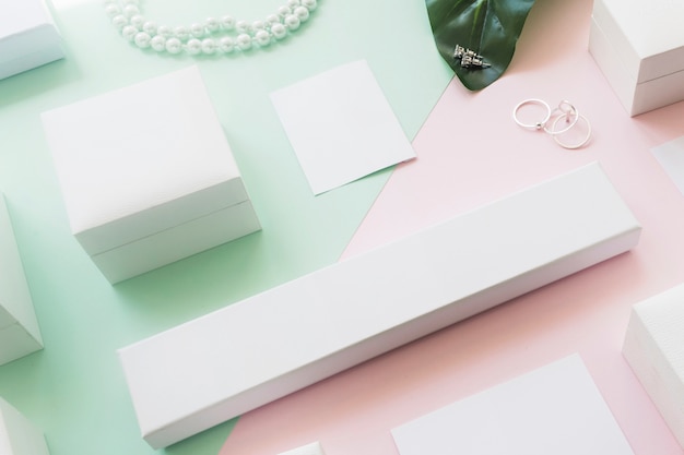 Overhead view of different white boxes on two green and pink paper backdrop