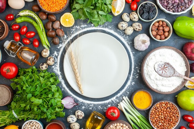 overhead view of dinner preparation with eggs fresh vegetables green bundles on dark blue