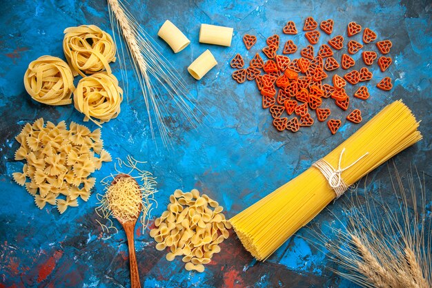 Overhead view of dinner preparation with pasta noodles on blue background