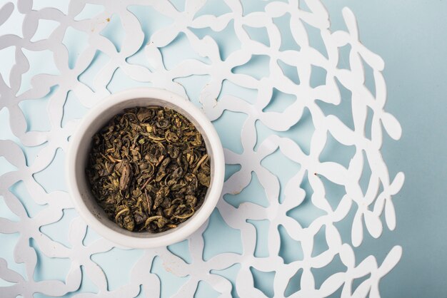 An overhead view of dried leaves bowl inside the white floral bowl