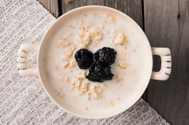 Overhead view of dry plum toppings on the oatmeal in the bowl