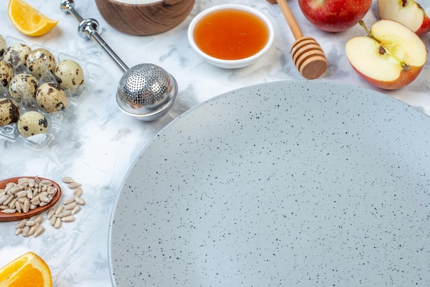 Overhead view of empty gray plate and fresh healthy food set on ice background