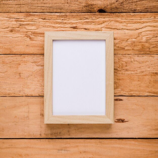 Overhead view of empty picture frame over textured desk