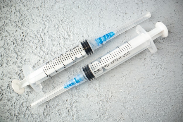 Free photo overhead view of empty syringes on gray sand background with free space