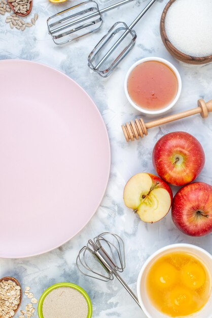 Overhead view of empty white plate and fresh healthy food set on two-toned background