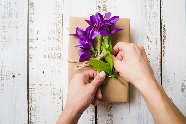 紐で結ばれた小包の偽の紫色の花のオーバーヘッドビュー