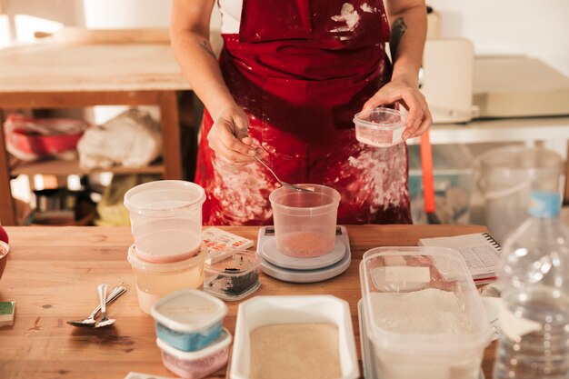 An overhead view of female pottery measuring the color powder