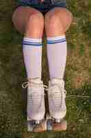 Free photo an overhead view of a female skater sitting on green grass