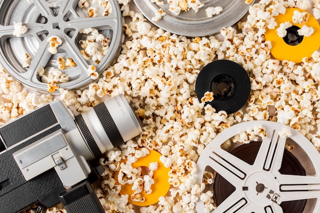 An overhead view of film reel; vintage camcorder; film reels on popcorn