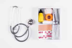 Free photo overhead view of first aid kit and stethoscope on white background