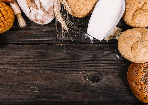 An overhead view of flour in shovel with baked breads on table