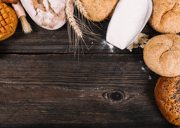 An overhead view of flour in shovel with baked breads on table