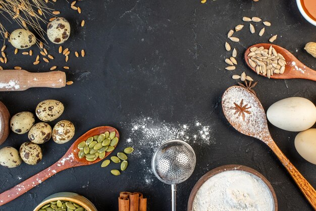 Overhead view of free space among flour cinnamon limes eggs honey on dark color background
