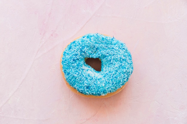 Free photo overhead view of fresh blue donut on pink background