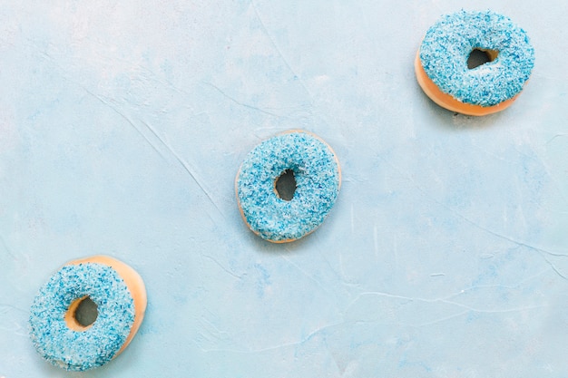 Overhead view of fresh donuts on blue background